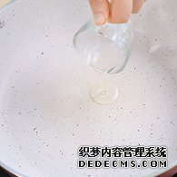 步驟圖:電陶爐開大火，煎炒鍋中倒入少許油。