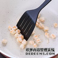 步驟圖:油熱后倒入蝦仁，用鍋鏟翻炒2分鐘至變色，盛出碗中備